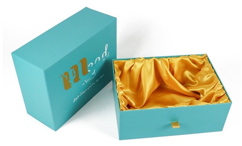 Close-up of soft golden silk lining inside premium clothing gift box